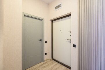 image showcases a modern interior with two doors, one grey with a geometric design and one white,...