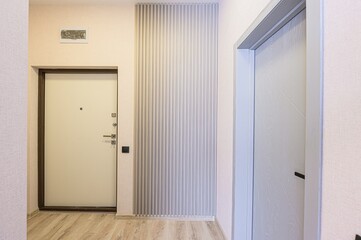 modern interior featuring a white door with a dark frame, a vertical panel detail, and a glimpse of...