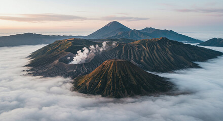 Aerial view of Mount Bromo volcano complex in Indonesia, with smoke rising from craters above a sea of clouds at sunrise.