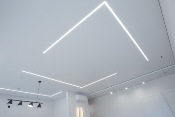 modern room interior with an emphasis on the ceiling. The ceiling is equipped with LED linear...