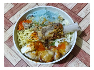 Bakso. A bowl of rib meatballs with yellow noodles, blue vermicelli, shredded cabbage, fried onions...
