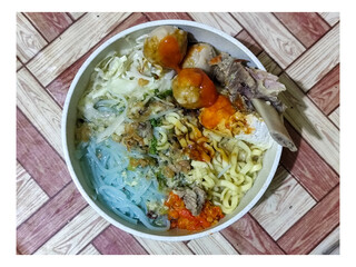 Bakso. A bowl of rib meatballs with yellow noodles, blue vermicelli, shredded cabbage, fried onions...