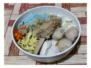 Bakso. A bowl of rib meatballs with yellow noodles, blue vermicelli, shredded cabbage, fried onions...