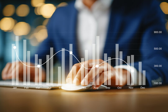 Businessman analyzing interactive bar and line graph showing monthly data performance on computer. Concept of data analytics, financial statistics, business intelligence, and KPI tracking.