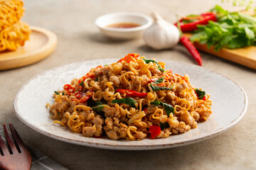 Stir fried instant noodles with minced pork and holy basil leaves in a plate.Thai spicy food.