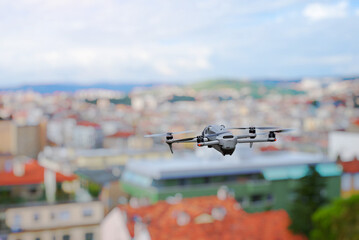 Rear view of drone flying over city buildings during daylight
