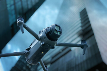 Close-up of a professional drone flying between skyscrapers in modern urban setting