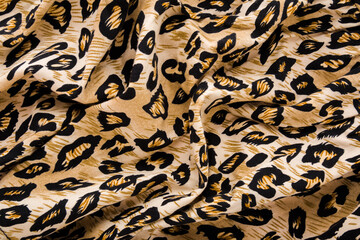 Dark black yellow soft wavy leopard spot pattern fabric background. Closeup. Top down view.