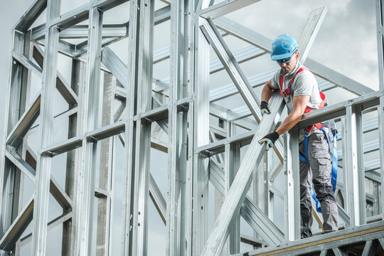 Construction Worker Assembling Metal Framework on Building Site During Daylight
