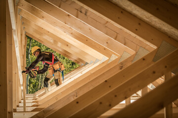 Construction Worker Builds Wooden Framework of Modern House in Daylight