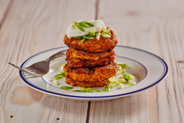 sweet potato latkes topped with sour cream and green onion