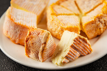 Cheese plate camembert, brie, munster french cheese tasty snack fresh delicious gourmet food background on the table rustic food top view copy space
