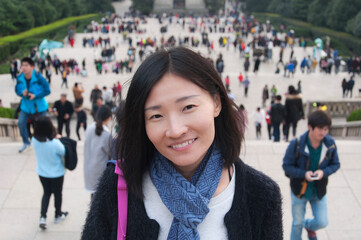 happy chinese woman with blurred people background nanjing china