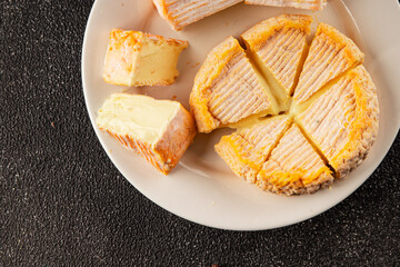 Cheese plate camembert, brie, munster french cheese tasty snack fresh delicious gourmet food background on the table rustic food top view copy space