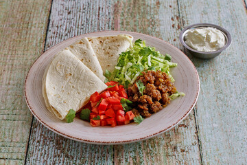 ground pork taco wraps with lettuce, tomato, and flour tortillas