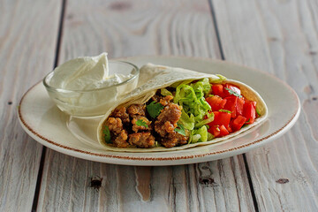 ground pork taco wraps with lettuce, tomato, and flour tortillas