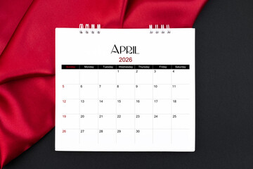 April 2026 Monthly desk calendar with red silk on black color leather background.