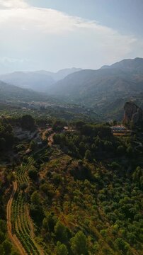 Drone video of the historic hilltop village of Guadalest in Spain, showcasing its ancient castle, charming houses, and surrounding mountains under clear blue skies.