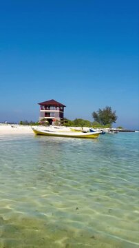Beautiful view of Kodingareng Island in South Sulawesi, Indonesia. Boat on the beac and clear water. Boat on the Island. Cottage on the Island. Holiday and nature tourism