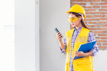 Woman construction engineer writing note wear plaid shirt safety white hard hat at construction...