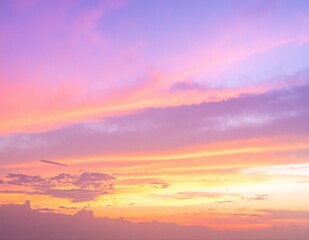 A breathtaking pink sky at sunset, with soft pastel hues blending seamlessly, casting a warm glow over silhouetted trees and distant hills.