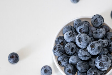 Blueberry is tasty, healthy and delicious fruits. Fresh blueberries heap in white bowl. Wild blueberries in plate with copy space for background.
