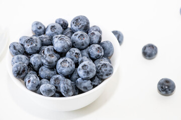 Blueberry is tasty, healthy and delicious fruits. Fresh blueberries  in white bowl. Wild blueberries in white plate on white background.