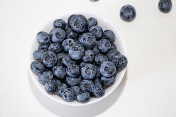 Blueberry is tasty, healthy and delicious fruits. Fresh blueberries  in white bowl. Wild blueberries in white plate on white background.
