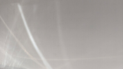 Soft ethereal play of light reflects and refracts on  clean white wall creating delicate luminous...