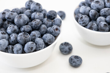 Blueberry is tasty, healthy and delicious fruits. Fresh blueberries  in white bowl. Wild blueberries in white plates on white background.