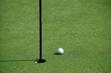 Golf ball near hole on green