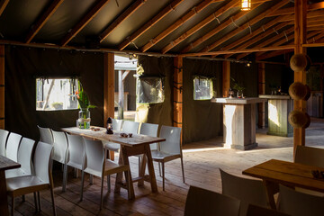 Wide view of rustic restaurant interior with wooden beams lanterns and traditional seating