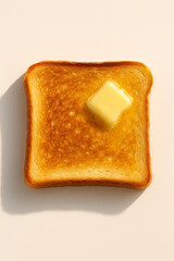 Golden toasted bread slice with melting butter on top casting soft shadow on light background