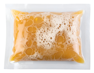 Vacuum sealed plastic pouch of yellow foamy liquid, food sauce or broth packaging on isolated white background