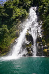 Fototapeta premium The waterfall at Lake Toba is a breathtaking sight, with crystal-clear waters cascading down into the lake's calm surface