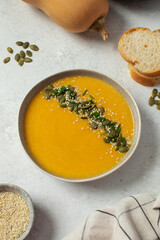Plate with pumpkin soup puree, pumpkin and sesame seeds. Autumn menu. 