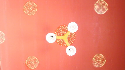 Thai temple ceiling with traditional floral patterns and modern lights