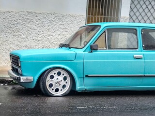 Old blue car on the sidewalk