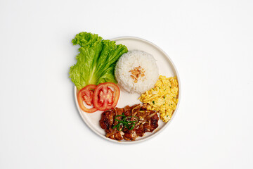 Top view of crispy chicken katsu served with curry sauce and vegetable fried rice on a brown ceramic plate, isolated on white background, Asian Japanese fusion cuisine concept.