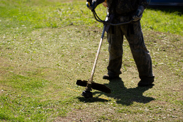 A trimmer for cutting grass and lawns on uneven surfaces.