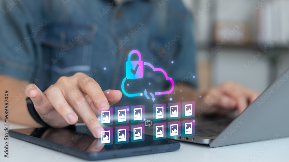 Poster person using tablet and laptop with secure cloud storage icon and photo file transfer concept, digit