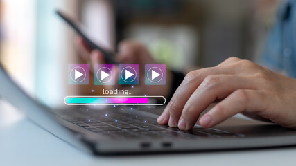 Person using laptop and smartphone with video streaming icons and loading progress bar, concept of online media, entertainment, and digital content technology.