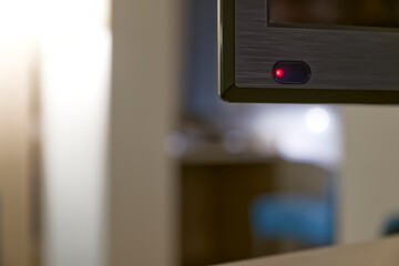 Monitor or TV power button with red light in modern interior