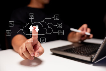 A person interacts with a digital interface displaying cloud computing icons on a laptop.