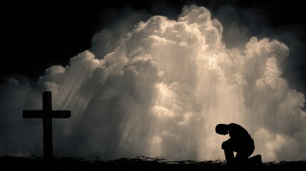 Silhouette of a person kneeling in prayer beside a cross with dramatic clouds in the background.