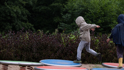 Children balancing and playing on spring platforms at playground