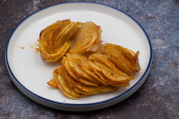 Crispy roasted vegan potato in airfrier- air fried casserole. Seved on ceramic plate.