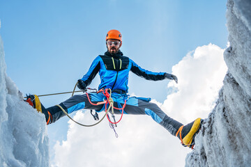 Climber in vibrant gear overcomes over crevasse on icy glacier during Lenin peak ascent under clear...