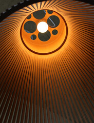 The cone shaped bamboo lampshade lets in a cozy, warm light from the lamp  
