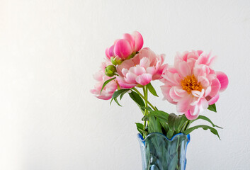 Beautiful peonies flowers in a vase on a light background. Postcard, place for inscription